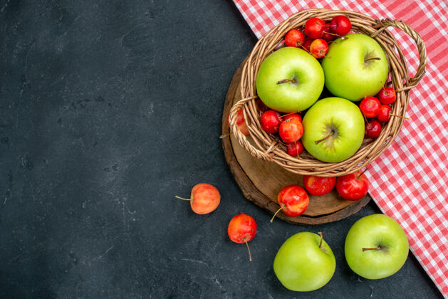 顶部顶视图篮子上有水果绿色的苹果和甜樱桃 表面呈深灰色 果实由浆果组成 新鲜度高生的吃苹果篮子