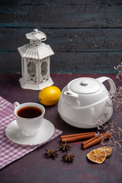 杯子前视一杯桂皮茶和茶壶上的深色茶水喝柠檬色的咖啡柠檬炊具