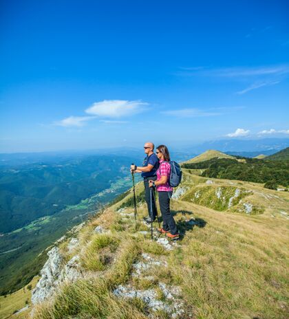 公园登山夫妇在斯洛文尼亚纳诺高原上观看美丽的维帕瓦山谷女人情侣攀岩者