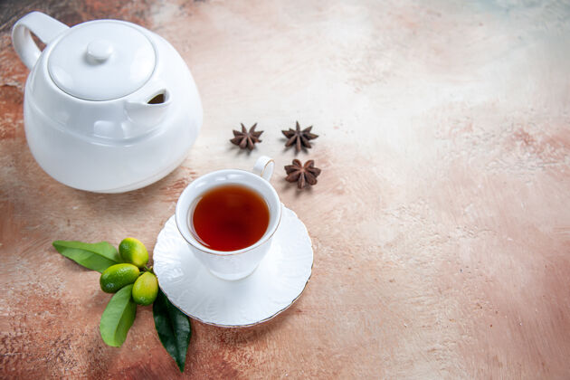 热的侧面特写一杯茶白色茶壶一杯茶八角柑橘类水果茶星星早餐
