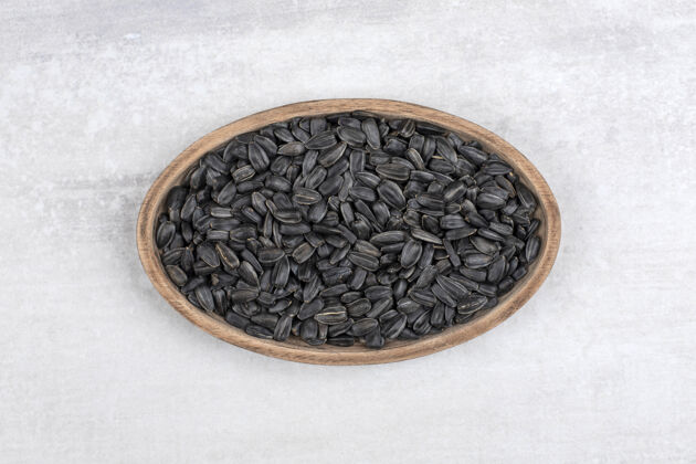 种子装满向日葵黑籽的碗放在石头上烤堆食物