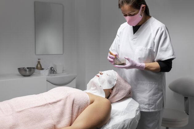 放松在美容院做面部护理的女人身体沙龙年轻