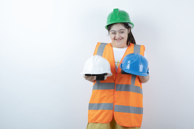制服戴着安全帽的年轻女建筑工人戴着头盔翻过白墙残疾女性表情