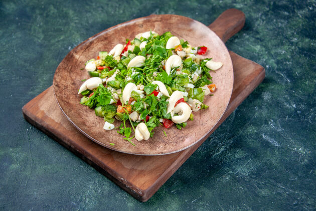 烹饪前视图蔬菜沙拉内优雅的深蓝色背景板沙拉晚餐饮食