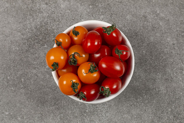 成熟美味的生西红柿在碗里 在大理石上收获可口有机