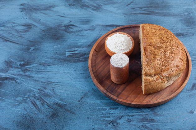 酵母两碗面粉和切片面包放在盘子里 蓝色的美味面粉可口