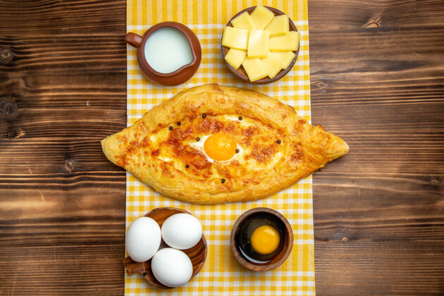 鸡蛋顶视图生鸡蛋与切片奶酪和牛奶在木制表面产品鸡蛋面团餐食品生早餐面团碗