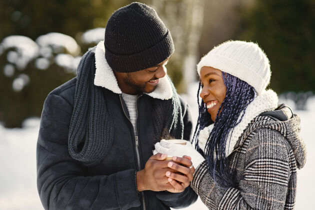女孩人们走在外面冬天非洲夫妇喝着咖啡情人节杯子两个