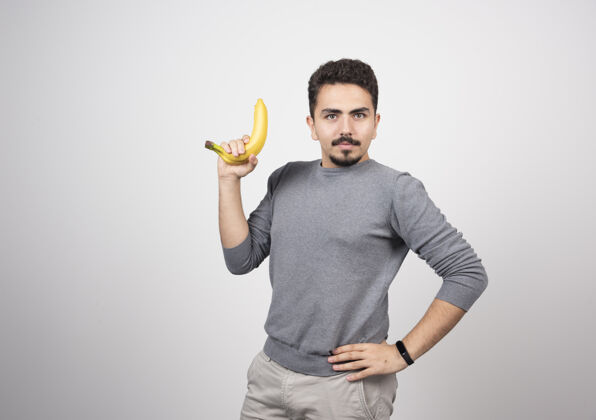 人一个拿着香蕉的年轻男模男孩姿势指向