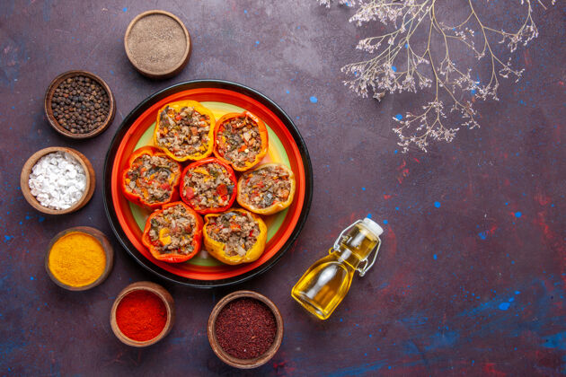 五颜六色顶视图熟甜椒与不同的调味料对深灰色的表面食物多尔玛蔬菜餐牛肉传统胡椒午餐