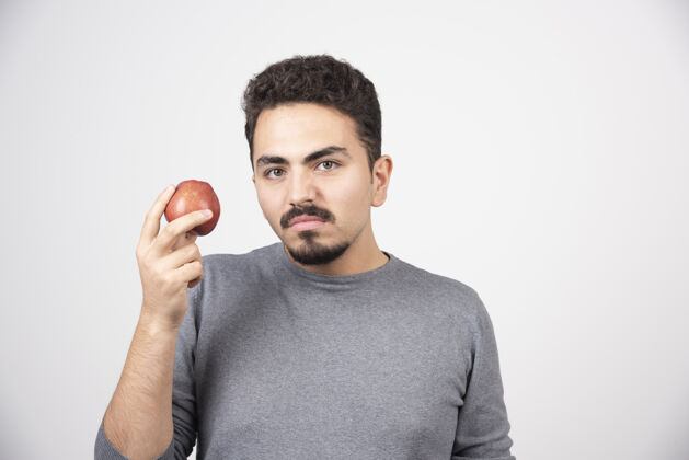 肖像年轻人愤怒地拿着红苹果水果年轻苹果
