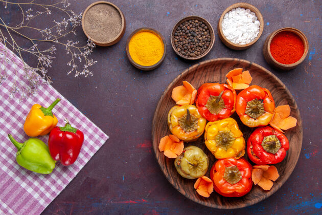 可食用水果顶视图熟甜椒与不同的调味料对深灰色表面蔬菜肉多尔玛一餐颜色卡路里的食物卡路里景观膳食