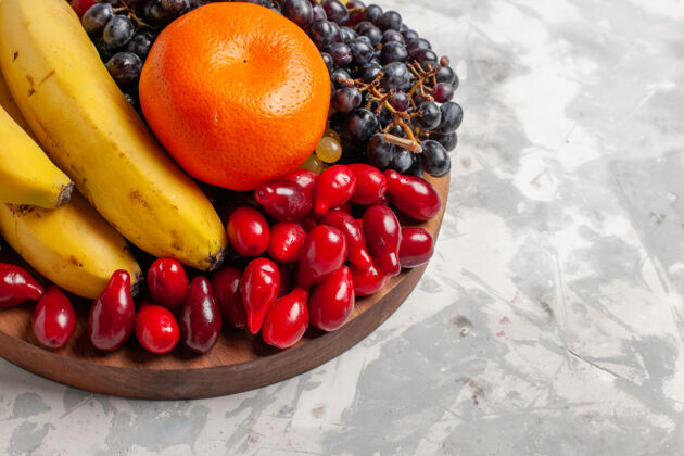 可食用水果前视图水果成分香蕉山茱萸和葡萄的白色表面水果浆果新鲜维生素葡萄番茄视野