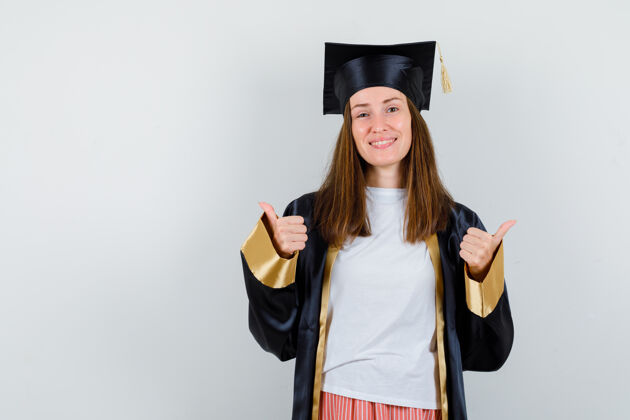 证书女毕业生穿着制服 穿着休闲服 竖起大拇指 看上去很快乐正面图学位妇女女性