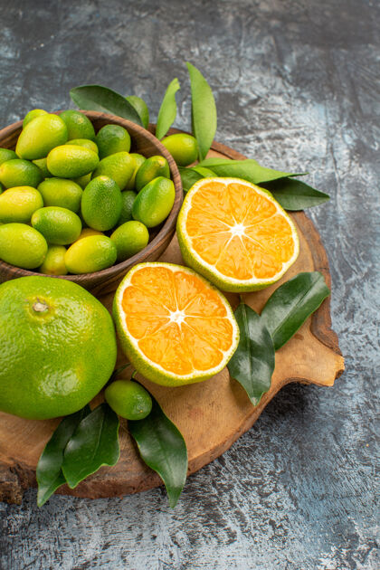 水果侧面特写查看柑橘类水果与树叶在木板上健康叶子特写