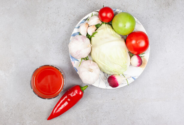 成熟盘子上一堆有机蔬菜和灰色表面上的酱汁的俯视图配料头顶大蒜
