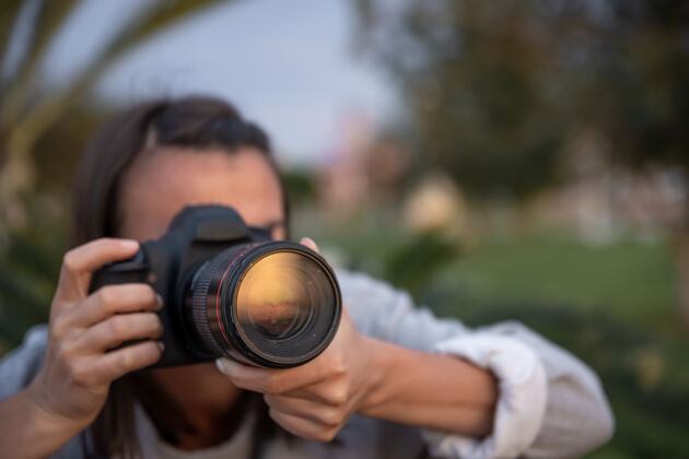 自然用专业单反相机在户外拍照的年轻女子特写摄影师女人