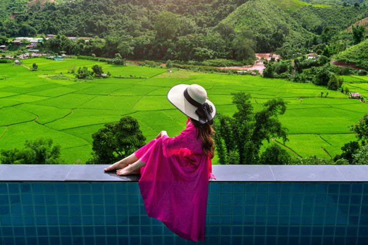 山泰国南部 一位欣赏稻田和绿色森林的女士欢乐乡村夏天