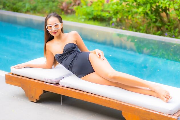 奢华美丽的亚洲年轻女子在游泳池里放松的画像阳光放松亚洲人