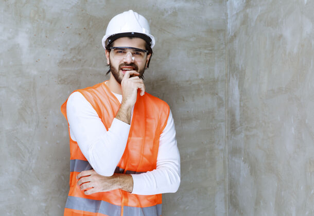 工人戴着白色头盔和护目镜的工程师看上去既困惑又体贴误导怀疑检查