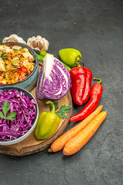 蔬菜前视图红色卷心菜与新鲜蔬菜在深灰色餐桌上健康成熟的饮食沙拉食物饮食辣椒
