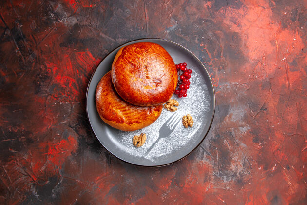 蛋糕俯瞰美味的馅饼与红色浆果在黑暗的桌子上甜甜的蛋糕馅饼浆果小吃食品