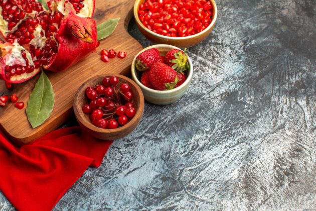 水果前视图切片石榴新鲜的红色水果在一个浅黑色的桌子上美食新鲜碗