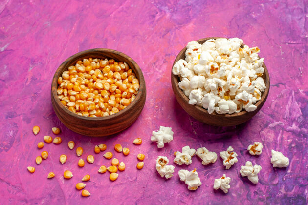 电影前视图新鲜爆米花与生玉米对粉红桌玉米电影电影院碗爆米花玉米