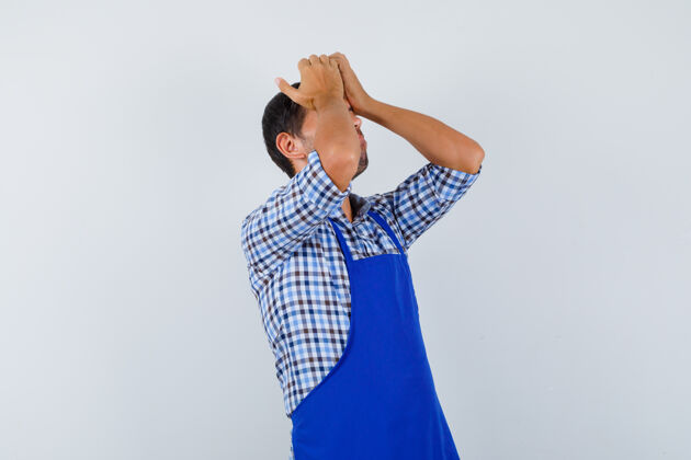 年轻穿着蓝色围裙和衬衫的年轻男厨师男士男士厨师