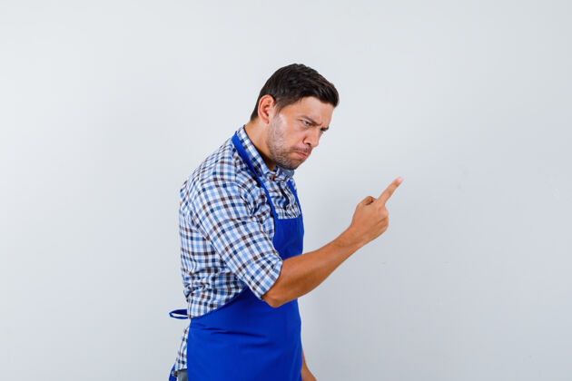成人穿着蓝色围裙和衬衫的年轻男厨师男士制服烹饪