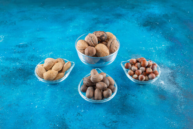 美味各种各样的坚果放在蓝色的碗上杏仁自然营养