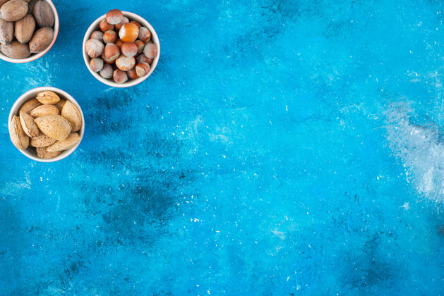 营养蓝色表面的碗里有各种各样的坚果美味风味榛子