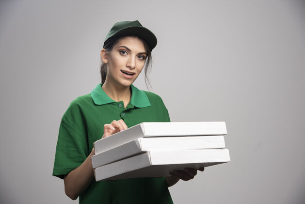 职业女信使摆出披萨盒的姿势杯子工作食物