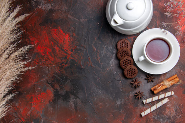 早餐俯瞰一杯茶 茶壶和饼干放在黑暗的桌子上垃圾容器茶杯