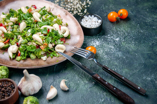 正餐前视图蔬菜沙拉内优雅的盘子与餐具在深蓝色的背景烹饪饮食晚餐