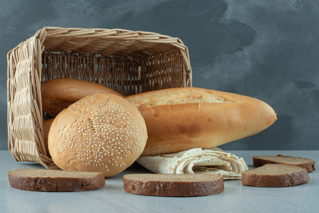 美味篮子里有各种各样的面包 石头桌上有小麦健康美味面包