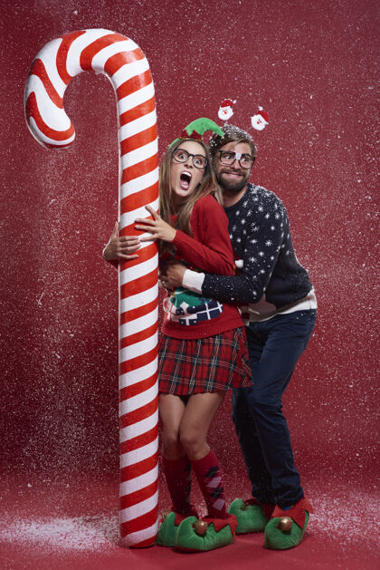 邦德穿着奇怪圣诞服装的年轻夫妇女人尖叫糖果手杖