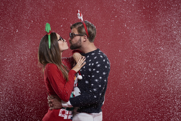 极客穿着奇怪圣诞服装的年轻夫妇眼镜雪花开衫