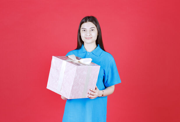 生日女人手里拿着一个用白丝带包着的紫色礼盒礼物庆祝休闲