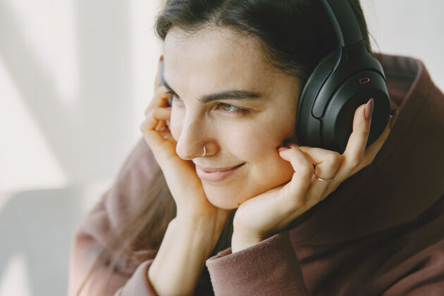微笑戴着耳机的快乐女孩在家听音乐享受休闲和谐