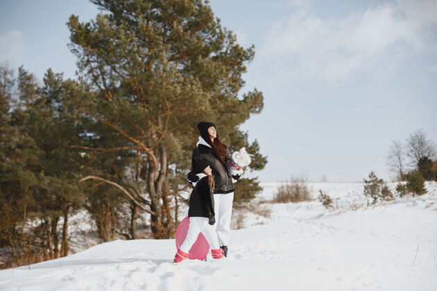 雪一家人在一起过圣诞节女人和小女孩在森林里人们在散步户外自然雪地