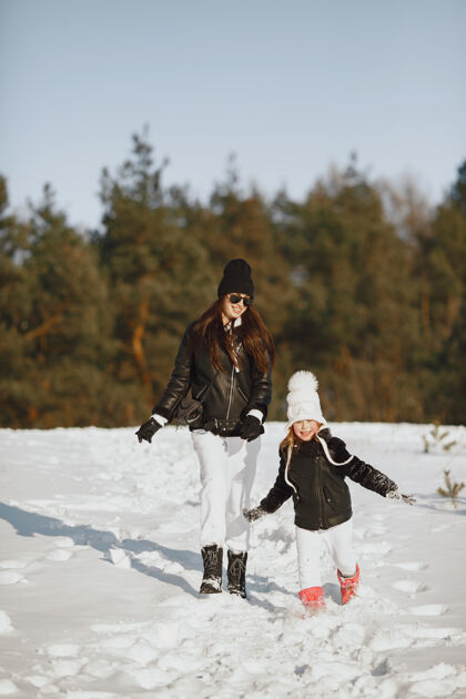 户外一家人在一起过圣诞节女人和小女孩在森林里人们在散步夹克冬天女性
