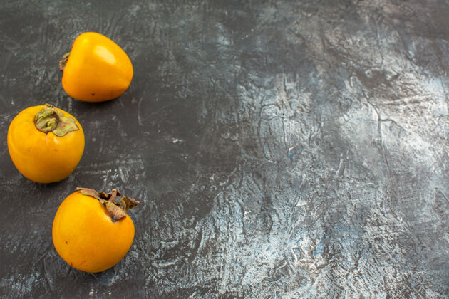 多汁侧面特写柿子灰色背景上的开胃柿子橘子壁板灰色