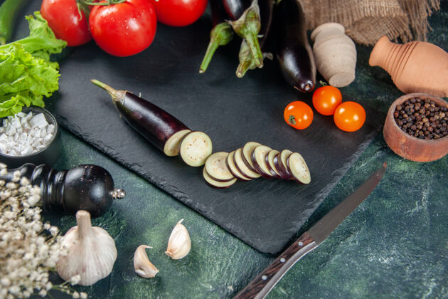 食物上图：新鲜的红色西红柿和深色背景上的茄子饮食健康西红柿