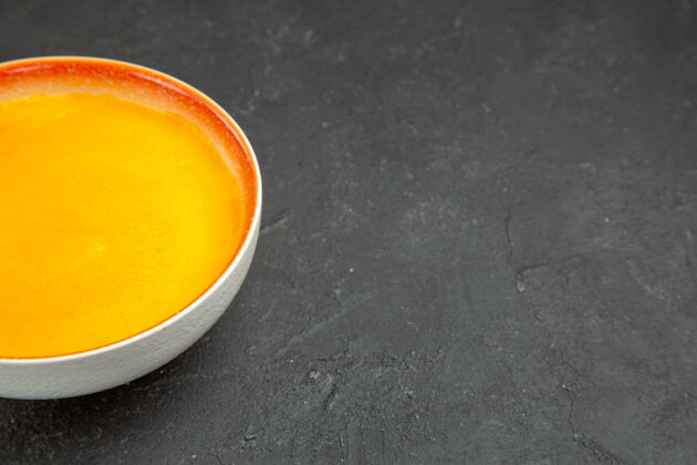 健康灰色桌子上的盘子里有简单的南瓜汤用餐前面食物