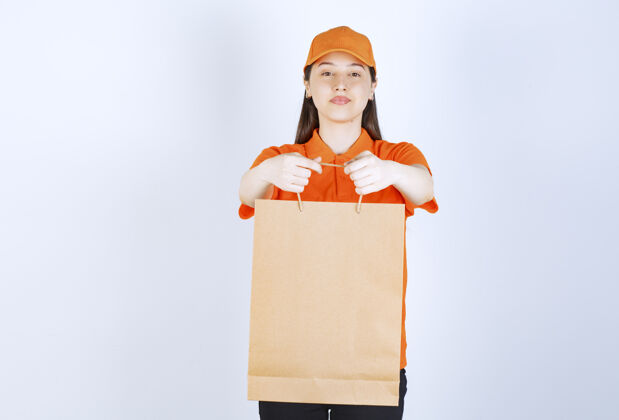 工人身着橙色制服的女服务人员手持购物袋 向顾客展示快速人员成人