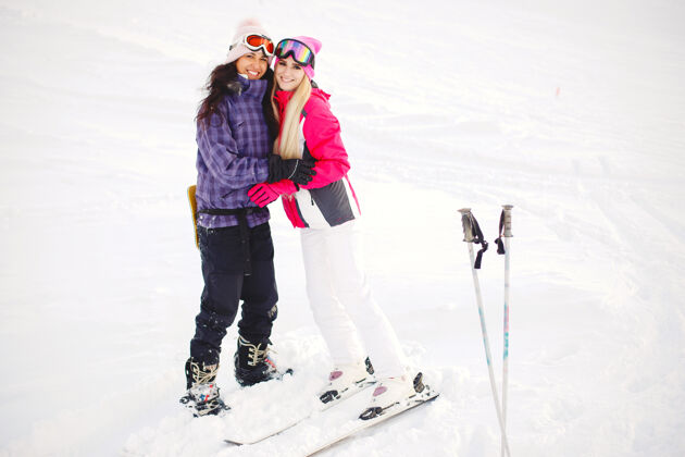白色女孩手中的滑雪用具滑雪服颜色鲜艳 姑娘们在一起玩得很开心滑雪乐趣滑雪者