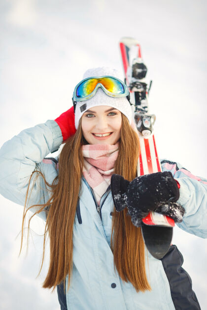 眼镜在雪山的背景下 滑雪者在山坡上摆姿势蓝色女人滑雪