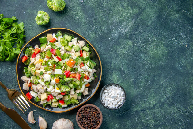 盘子顶视图美味的蔬菜沙拉在盘子里用餐具在黑暗的背景下烹饪餐厅新鲜的一餐健康午餐饮食美味膳食美食