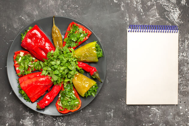 五颜六色的胡椒顶部特写查看彩色胡椒盘胡椒与草药旁边的白色笔记本新鲜笔记本盘子